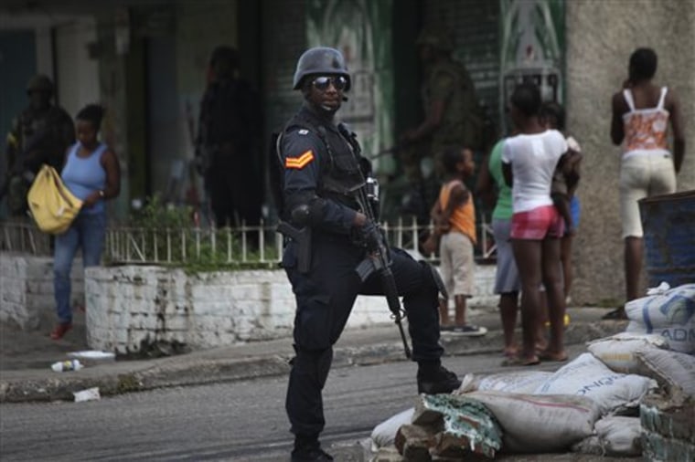 A policeman stands guard at a check point in Tivoli Gardens neighborhood, Kingston, Sunday, May 30. 